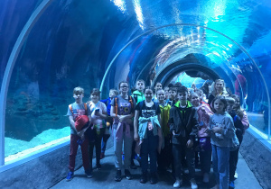 Uczniowie stoją w podwodnym tunelu